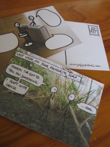 Three postcards. One shows the reverse, with a little mock stamp drawing on it. One shows a PiP comic with the text erased from the speech bubbles. One shows a recent comic in full.