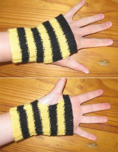 A pair of black and yellow striped handwarmers viewed from the palm and back of the hand. Each glove has alternating yellow and black stripes, four of each colour, and each stretches from knuckles to wrist bone.